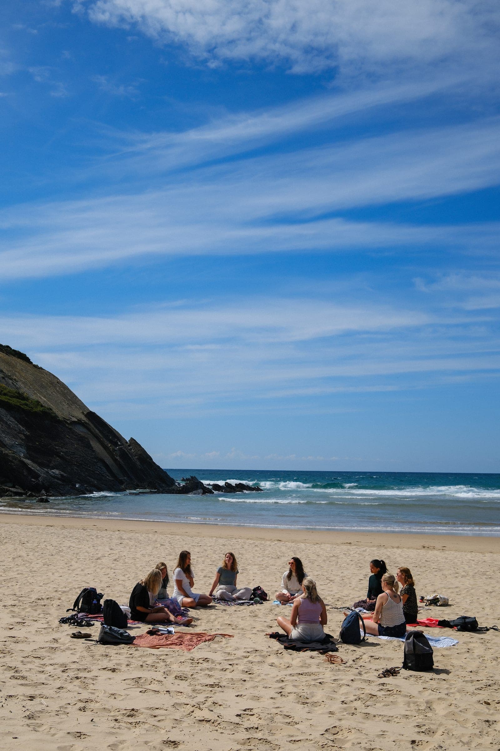 De groep in een kring op het strand
