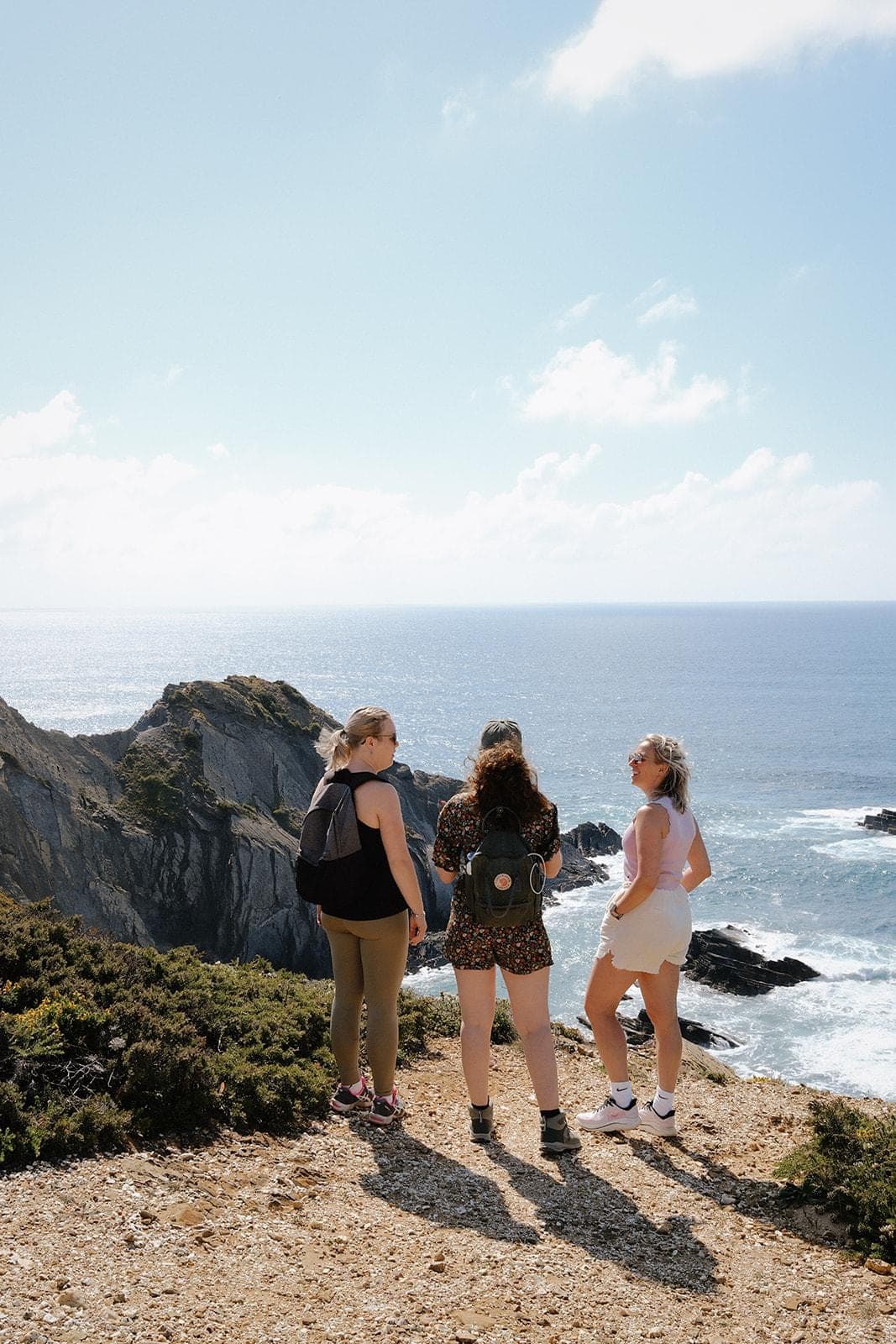 Drie vrouwen genieten samen van het uitzicht over zee